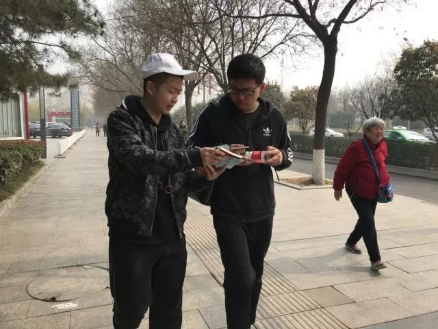 同学们向人民群众宣传禁毒知识并分发禁毒手册